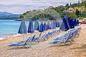 View of empty beach Ã¢â¬â blue deck chairs and umbrellas near sea water